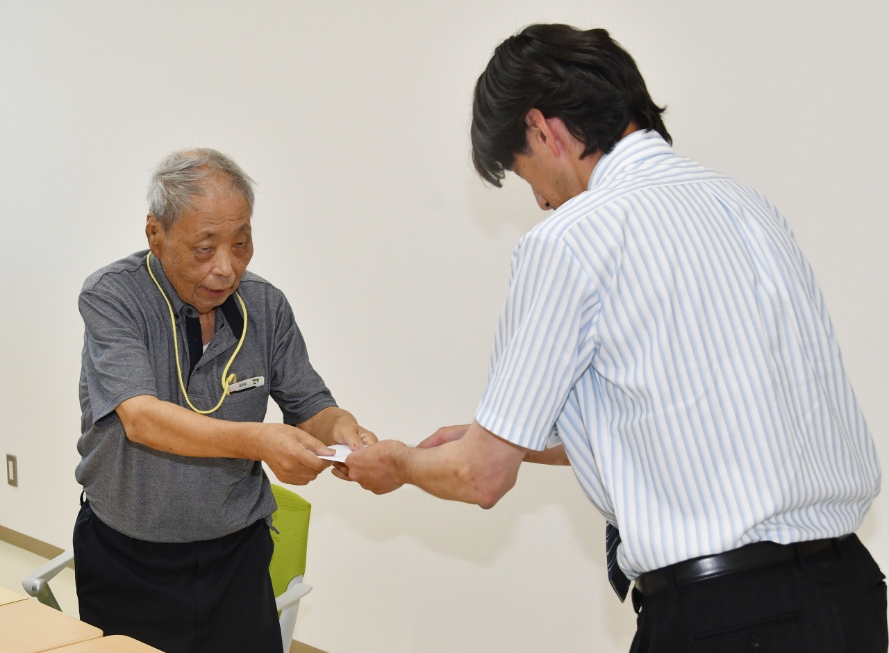 町担当者(右)に要請書を手渡す道祖土正則代表=28日、大間町役場
