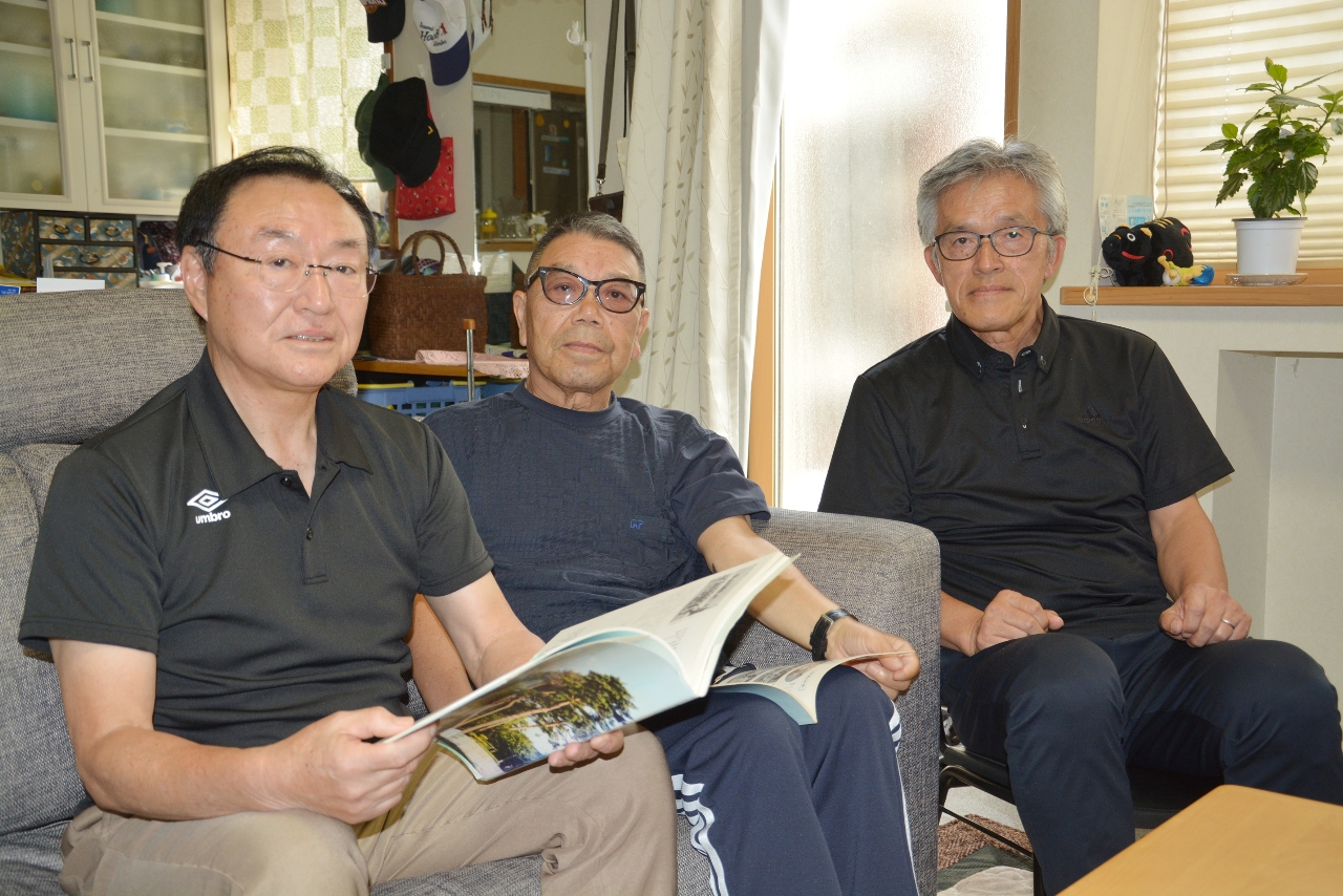 記念誌をめくり「あすなろ国体」を振り返る3人。当時顧問の杉原広さん(中央)、選手の田鎖豊さん(左)、内野主税さん=三沢市