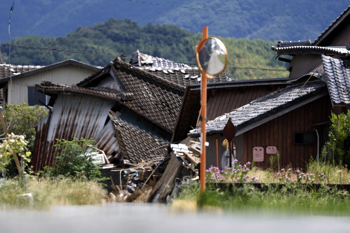 厳しい暑さの中、かげろうが立ち上る熊本県氷川町に残る被災家屋=26日
