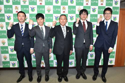 小又勉町長(中央)と一緒に意気込む髙田浩司さん(右から2人目)と大森直樹さん(同4人目)