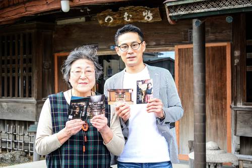 新むつ旅館の魅力を詰め込んだポストカードを制作したボランティアの星野達郎さん(右)と、おかみの川村紅美子さん=4月中旬、八戸市