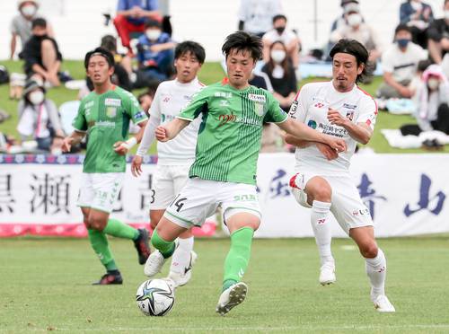 【宮崎―八戸】前半、相手と競り合う八戸のMF前澤甲気(14)=6日、宮崎県ユニリーバスタジアム新富