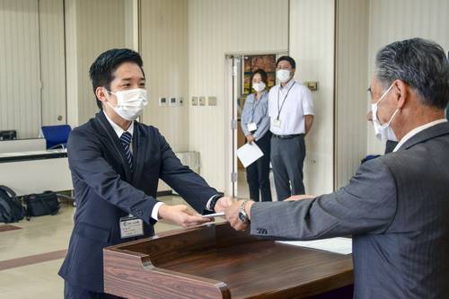 成田隆町長(右)から辞令を受け取る久保田仁さん