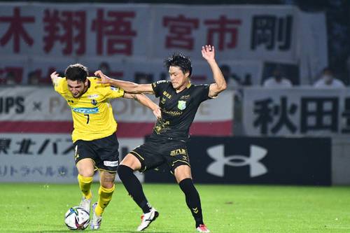 【岩手―八戸】後半、競り合う八戸のMF佐藤和樹(右)=盛岡市いわぎんスタジアム(ヴァンラーレ八戸提供)