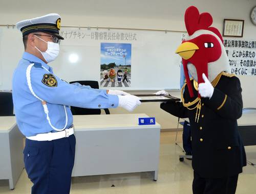 南部一成署長(左)から一日警察署長に任命されるキングオブチキン