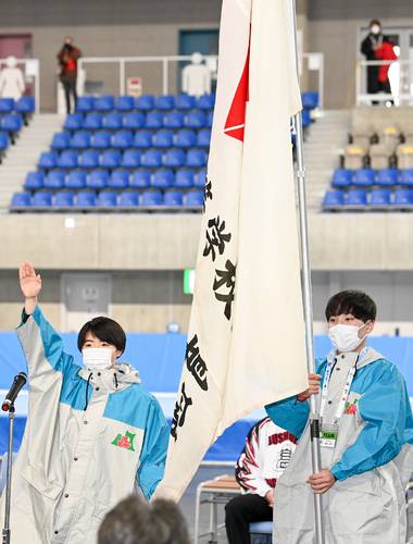 全国高校スケート・アイスホッケー選手権の開始式で選手宣誓する八戸西の下村璃々(左)と、青森県選手団旗手を務めた工大一高の寺地優人=17日、YSアリーナ八戸