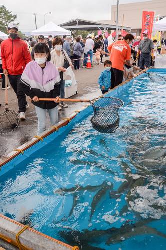 たも網で海峡サーモンをすくう子どもら