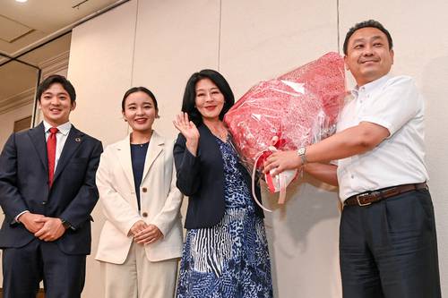 夫(右)から花束を手わたされ、家族とともに笑顔をみせる広瀬めぐみ氏(右から2人目)=10日夜、盛岡市
