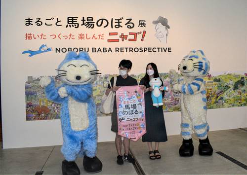 「11ぴきのねこ」のキャラクターからユニークなダンスで祝福される渋谷直寿さん、佑佳さん夫妻=28日、八戸市美術館