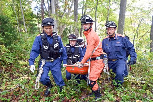 訓練で遭難者を担架で運ぶ関係者