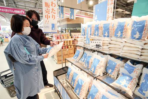 店頭に並んだ「はれわたり」を手にする来店客=29日、八戸市