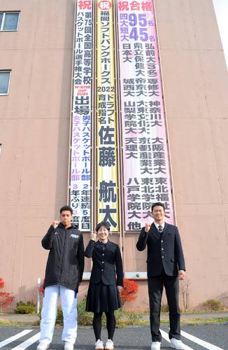 懸垂幕の前で全国大会での活躍を誓う(左から)男女バスケットボール部の古澤然主将、副島紗和主将、プロ野球育成ドラフトで指名を受けた佐藤航太=八学光星高