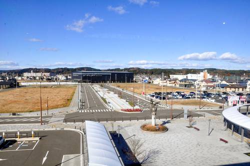 土地区画整理事業が進む八戸駅西地区。奥に見える「フラット八戸」は開業したが、駅前は空き地が目立つ=22日、八戸市