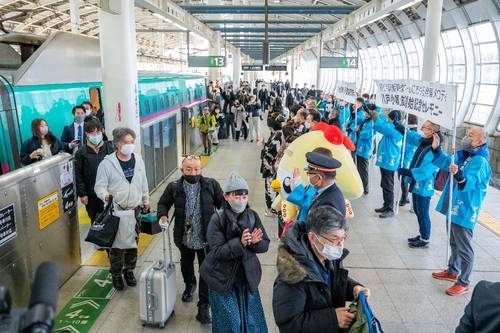 「八戸小唄」の発車メロディーが流れる中、新幹線から降り立つ観光客やビジネス客らを出迎える地元関係者=1日午前9時20分ごろ、八戸駅新幹線ホーム