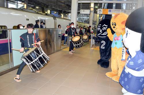 二戸駅の新幹線ホームで列車を出迎えるゆるキャラと、二戸市ナニャトヤラ保存会の太鼓=3日午前11時10分ごろ