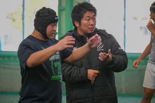 練習中、選手と意見を交わす橋本高行監督(右)=10日、弘前市
