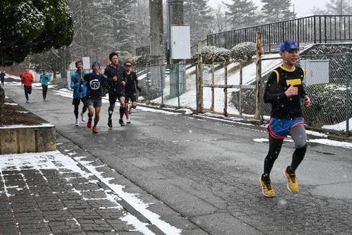 雪が降る中、力強い走りを見せる参加者