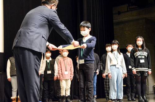 絵画コンクールで最優秀賞に輝き、油川潤一会長(左)から賞状を受け取る藤田絆鈴君