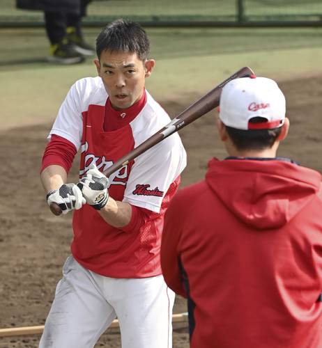 打撃練習で新井監督(手前)からアドバイスを受ける広島・秋山=日南