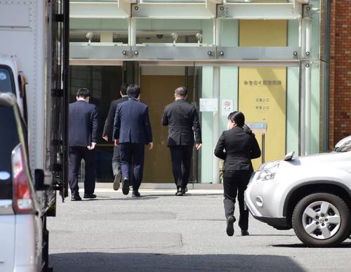 医師法違反などの疑いがあるとして、青森県警による家宅捜索が行われたみちのく記念病院。院内へ向かう捜査員とみられる一団=28日午前9時35分ごろ、八戸市
