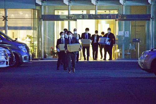 押収物が入った箱を持ち、みちのく記念病院から出てくる捜査員=28日午後6時55分ごろ、八戸市小中野1丁目