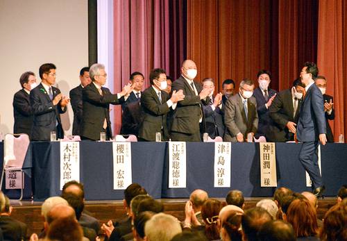 小野寺晃彦氏(右手前)を壇上で迎える来賓=6日、青森市