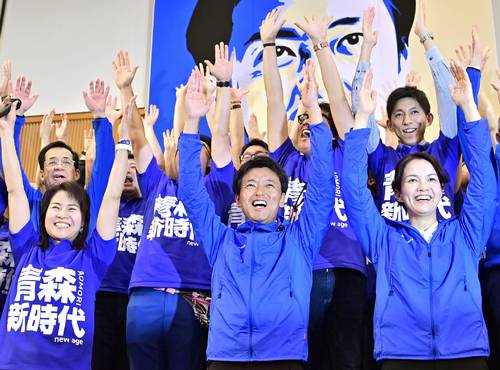 青森県知事選で初当選を確実にし、万歳する宮下宗一郎氏(中央)=4日夜、青森市