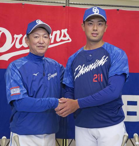 中日に支配下選手登録され、記者会見で立浪監督(左)と握手する松山=6日、さいたま市