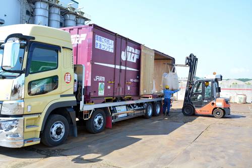 鉄道コンテナに出荷品を積み込む作業員。東京鉄鋼八戸工場は鉄路輸送の試行を開始した=8日、八戸市