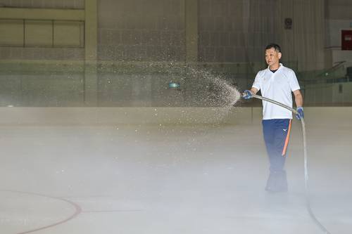 最高のリンクを目指し、結氷作業にあたるスタッフ=11日、テクノルアイスパーク八戸