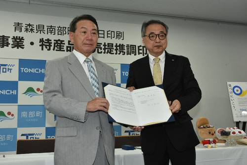 包括提携を結んだ工藤祐直町長(左)と武田芳明社長=20日、東京
