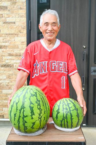 重さ約18キロのスイカ(左)を収穫した赤坂功さん