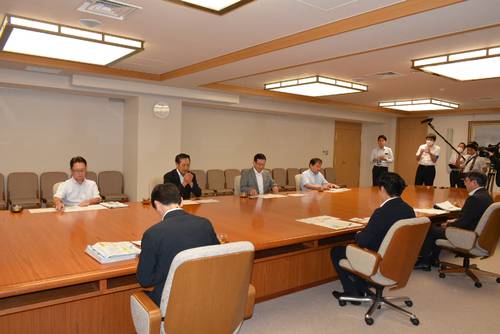宮下宗一郎知事(手前中央)に陸奥湾産ホタテガイの生産状況などを説明する県漁連の二木春美会長(奥左から2人目)ら=8日、県庁