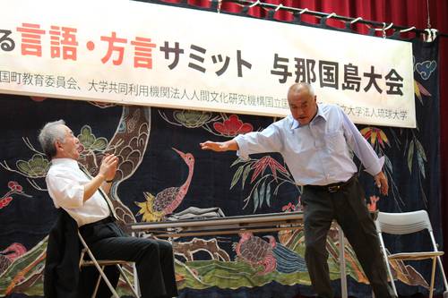 「危機的な状況にある言語・方言サミット」で2人芝居を披露する柾谷伸夫さん(左)と長谷川等さん=14日、沖縄県与那国町(柾谷さん提供)