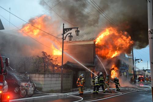 大きな炎が上がり、消火活動が行われる住宅=28日午後3時40分ごろ、おいらせ町下明堂