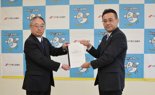 武輪俊彦会頭(左)に回答書を手渡す熊谷雄一市長=1日、八戸商工会館