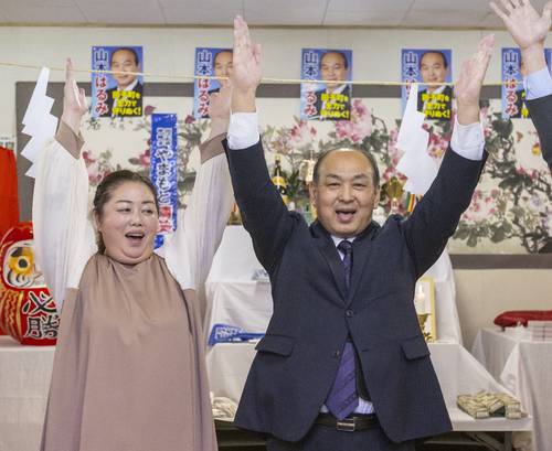 4選を果たし、万歳する山本晴美氏(右)と早月夫人=17日午後8時55分ごろ、田子町田子