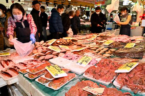ずらりと並んだ新鮮な魚介類を品定めする買い物客=28日、八戸市の八食センター