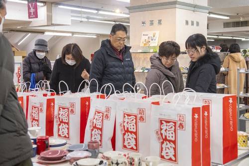 初売りで福袋の品定めをする来店客=1日午前10時15分すぎ、さくら野百貨店八戸店