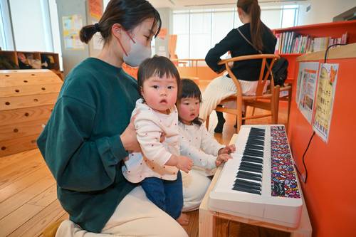 「ハラミちゃん」から寄贈された電子キーボードで遊ぶ親子連れ