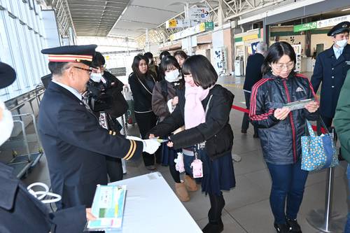 受験生応援グッズを受け取る駅利用客ら