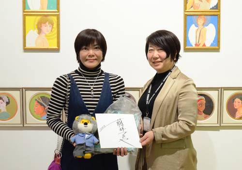 7千人目の観覧者となり、宗石美佐副館長(右)から記念品を受け取る小林浩美さん=28日、八戸市美術館