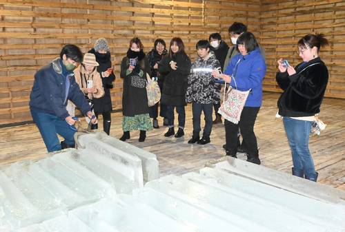工場で製造された氷を撮影する参加者