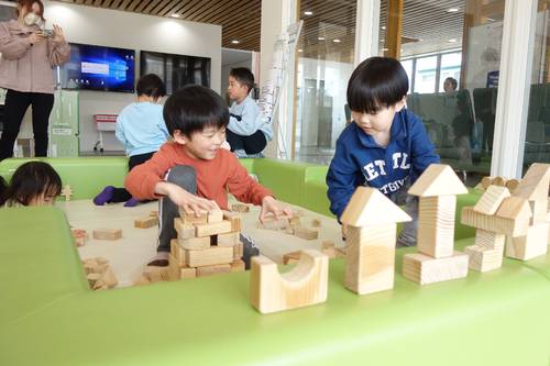 青森県産材の積み木で思い思いに遊ぶ子どもたち=28日、南部町