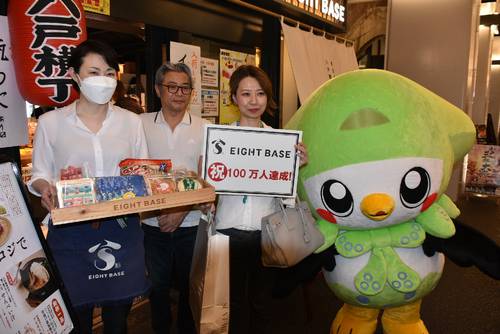 100万人目の来店者となり、笑顔を見せる菊池和紀さん(左から2人目)、宰里さん(同3人目)夫妻と女将の高橋泰恵さん=15日、東京都内