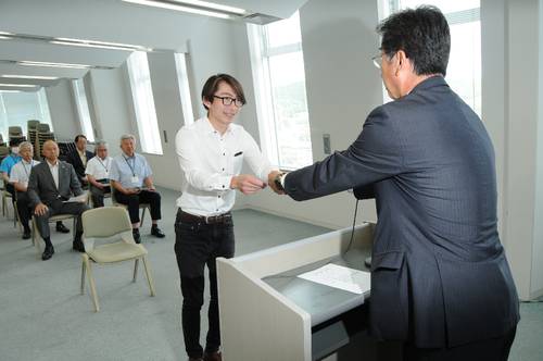 松尾和彦町長から辞令を受ける山下史寛さん(中央)