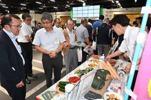 生産者らが夏野菜の新品種や人気品種を見て回った品種見本市=2日、八戸市