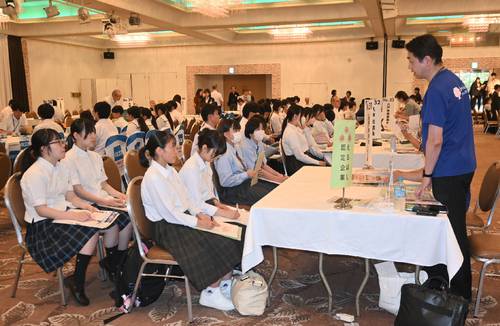 企業の担当者(右)の話に耳を傾ける生徒=9日、八戸市