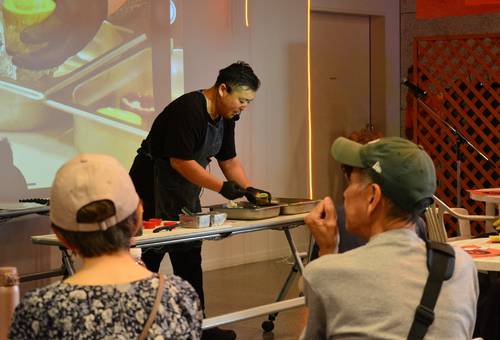 根市拓実代表(奥)による「糠塚きゅうり」のレシピ公開や料理の振る舞いは好評を博した=7月中旬、八戸市