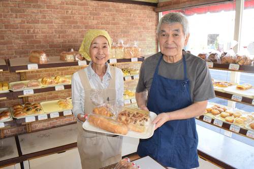 多彩な手作りパンを販売する「ブレッドハウス エピー」の藤田泰さん(右)、弘子さん夫妻